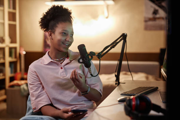 istock Smiling Black Girl Using Microphone Live Streaming Videogames 1980152684