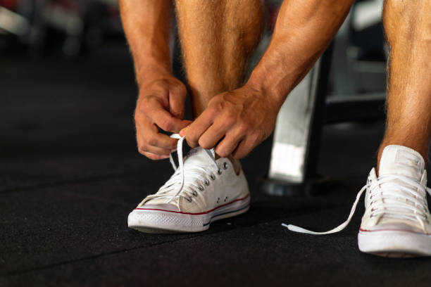 istock Sport man tying his shoelaces before a workout in a gym.Cropped image. 1980156437