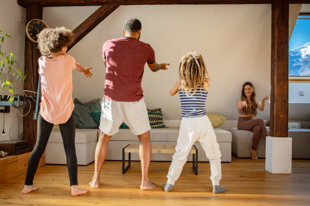 istock Father and his two children dancing at home 1980157566