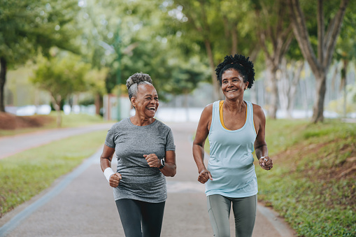 Two women friends doing exercises together senior and mature