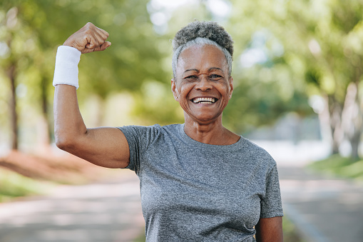 Senior woman making strength sign with arm raised
