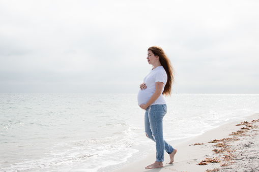 Pregnant woman enjoying the ocean. Pregnant woman on the beach. Happy healthy pregnancy.  wellness concept. Maternity care