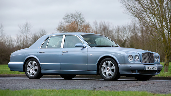 Milton Keynes,UK-Jan 18th 2024: 2005 blue Bentley Arnage luxury car driving on an English country road.