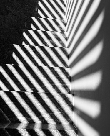 Graphic shapes - parallel shadow lines on stairs. High contrast.