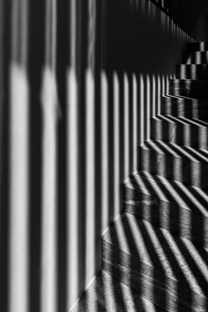 istock Graphic shapes - parallel shadow lines on stairs. High contrast. 1980221613