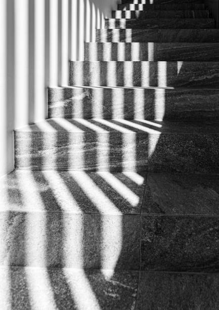 istock Graphic shapes - parallel shadow lines on stairs. High contrast. 1980221615
