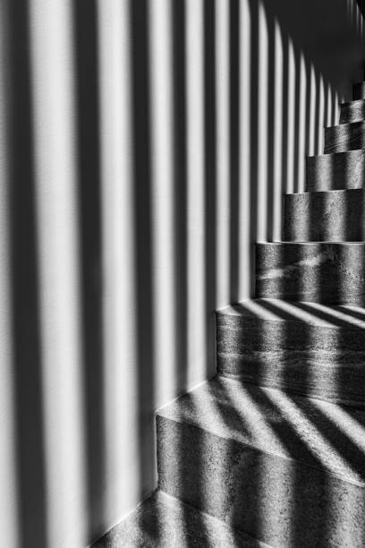 istock Graphic shapes - parallel shadow lines on stairs. High contrast. 1980222126