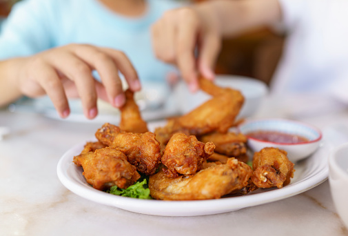 A plate of crispy shrimp paste fried chicken wings served with Thai chili sauce offers a delectable combination of crunchy chicken wings with a flavorful dipping sauce, providing a tantalizing culinary experience.