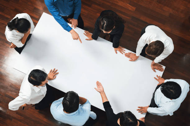istock Businesspeople on meeting table pointing to empty space. Prudent 1980232200