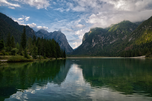 Scenic lake nestled amidst majestic mountains and encircled by lush pine trees