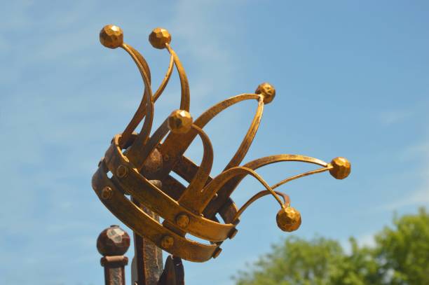Bronze golden crown, against the blue sky. Architectural vintage metal element.