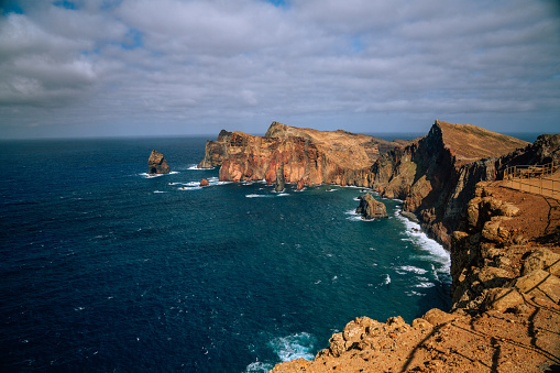 Breathtaking view of the turquoise water and tall cliffs by coastline of Madeira in Portugal