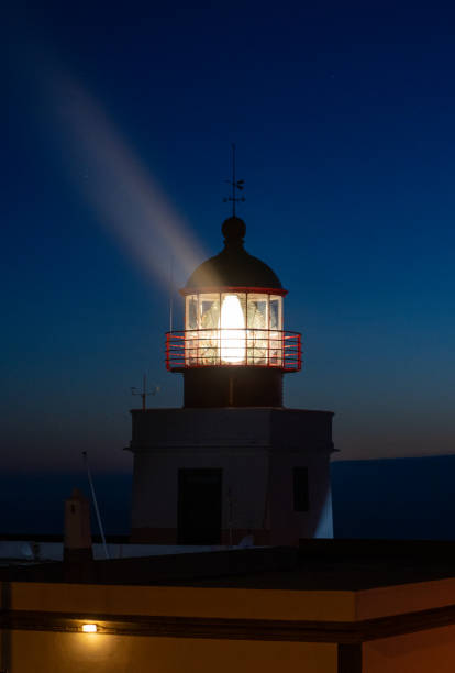 istock Tall white lighthouse building at night guiding ships back home 1980267388