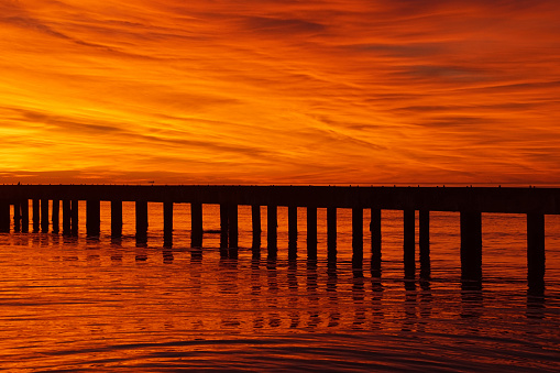 sunset with a pier on the sea at cinquale di montignoso