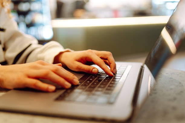 istock Close-up of hands working on a laptop keyboard. 1980289110