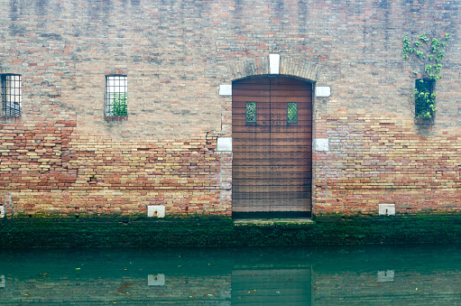 Vintage door and the detail of the Venetian building with a part of a canal