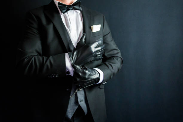 istock Gentleman in Dark Suit Pulling on Leather Gloves 1980309902