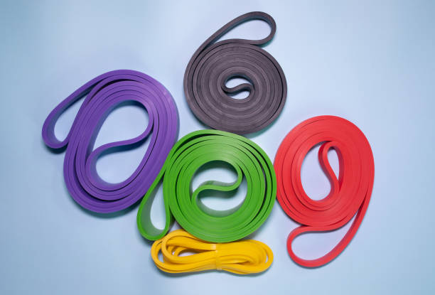 istock Multicolored exercise rubber band fitness on blue background. 1980346480