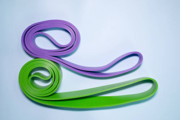 istock Multicolored exercise rubber band fitness on blue background. 1980346491