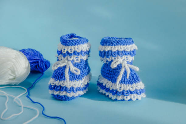 istock knitted blue booties socks with balls of thread for knitting 1980396216