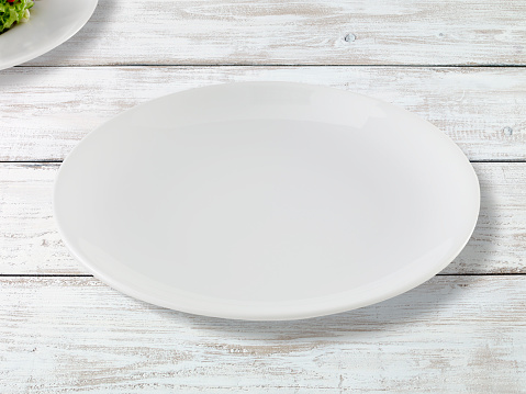 Empty service plate on a white painted wooden table