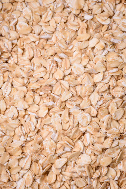 istock Raw oatmeal flakes in a ceramic bowl on a dark concrete background 1980457258