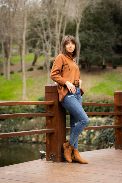 Pretty young lady is walking around at public park in autumn.