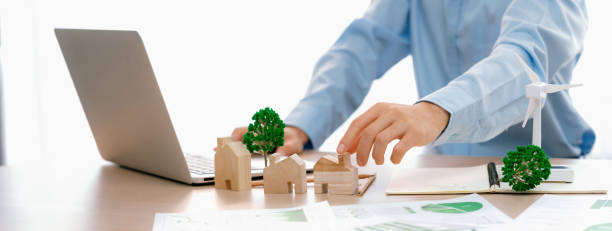 istock Professional architect plans to use green design in an eco house. Delineation. 1980495327