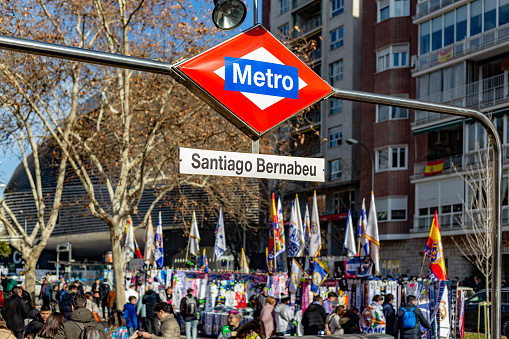 Madrid, Spain. In the hours leading up to the start of the Real Madrid football match, street stalls selling items related to Real Madrid (flags, scarves, etc.) can be found, especially at the metro exits or bus stops heading to the Santiago Bernabéu stadium.