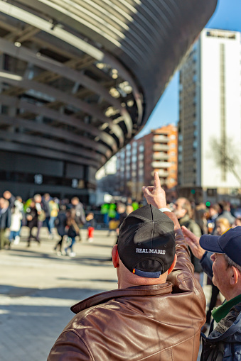 Madrid, Spain. Pair of older Real Madrid fans discussing the renovation and improvements of the Santiago Bernabeu stadium.