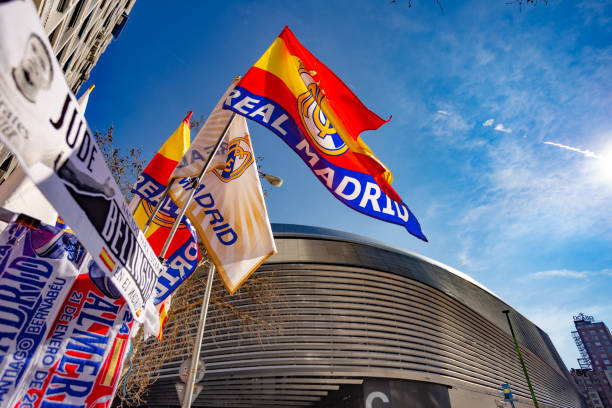 straßenstand mit schals und fahnen von real madrid in der nähe des santiago-bernabéu-stadions am spieltag - spain flag built structure cloud stock-fotos und bilder