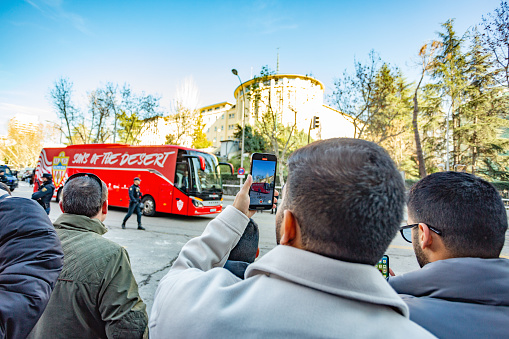 Madrid, Spain. Fans take photos with their mobile phones of the arrival of the Almeria CF football team bus at the Santiago Bernabeu stadium to play a football match against Real Madrid.