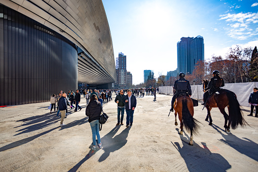 Madrid, Spain. Fans strolling by the stadium, mounted police officers supervising the atmosphere around the stadium on a sunny winter afternoon.
