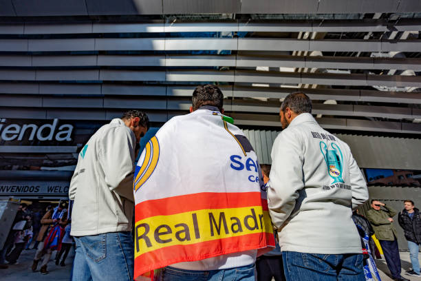 low rear view of real madrid fans with flags and team jerseys, waiting to enter the santiago bernabeu stadium. - real madrid vs 個照片及圖片檔