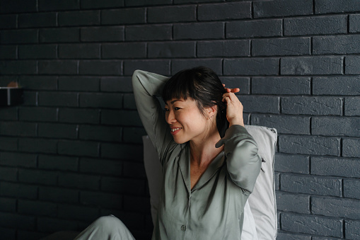 Photo of a smiling Japanese woman waking up