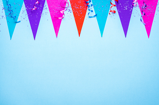 Party or carvival backgrounds: Flags garland, streamers and confetti on blue background