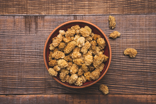 Dried white mulberry on wooden background