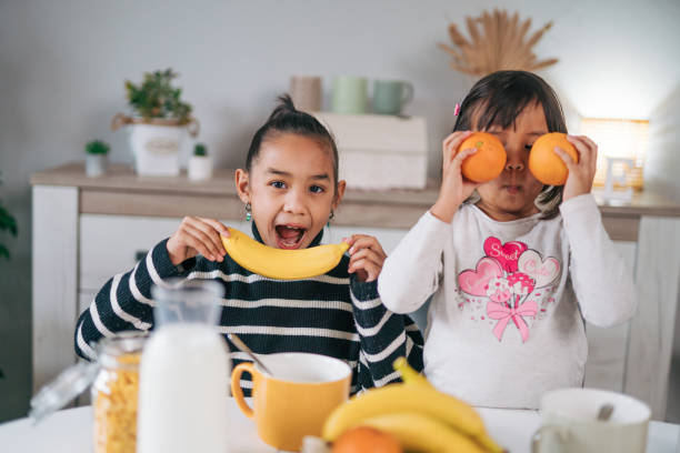 istock Happy two cute children playing with fruits 1980614399