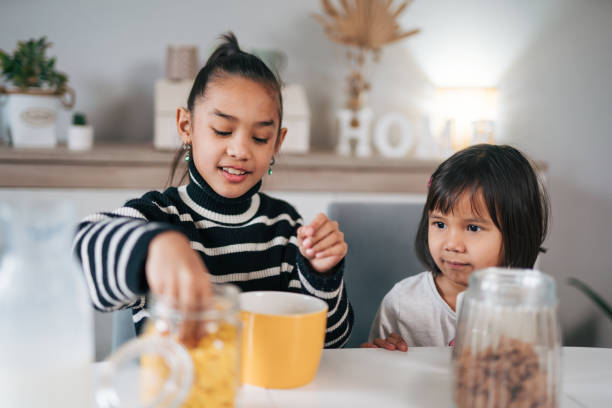 istock The older sister making cereal and milk 1980632181