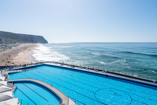 Lisbon, Portugal - Oct. 2, 2023: Praia Grande Beach and Swimming pool at dusk, Sintra, Portugal.