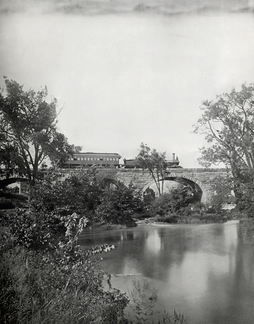 Steam freight passenger train travelling across Mill Creek Bridge in Pennsylvania rail road - famous iconic form of transportation in USA 

The Pennsylvania Railroad, aka The Pennsylvania Railroad Company, aka the 