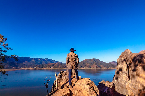 Persona de frente a un acantilado ennun valle con un lago en valle de bravo estado de México