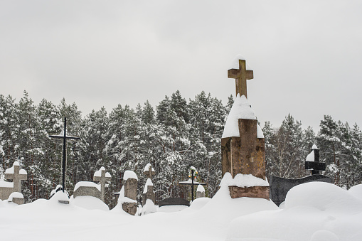 Snowy crosses on cemetery. Cemetery covered by snow in winter.