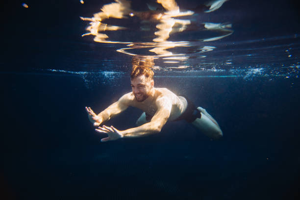 istock A young man swims underwater in a pool. Summer vacation concept. 1980736440
