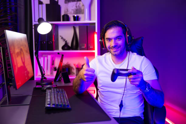 istock Smart gaming streamer with joystick looking camera with shooting game. Surmise. 1980738017
