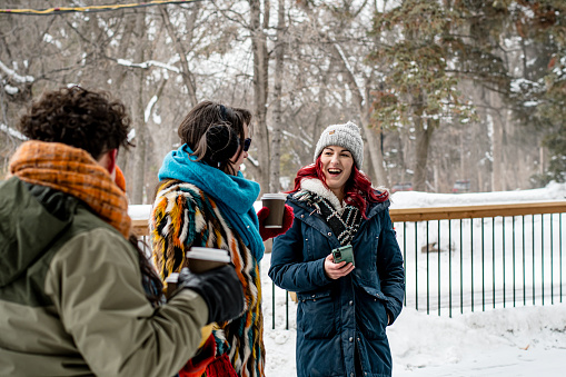 A beautiful moment unfolds as an inclusive trio, featuring a non-binary autistic individual, a woman, and their trans friend, shares a warm welcome in the winter wonderland