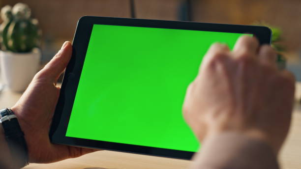 istock Unknown businessman scrolling chroma key tablet working online at office closeup 1980794901