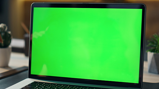 Unknown woman freelancer speaking to green screen laptop at remote workplace. Professional manager talking at video conference on computer chroma key. Worker videocalling at mockup device close up.