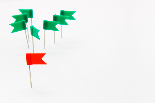 Red thumbtack shaped like a flag leading a green group