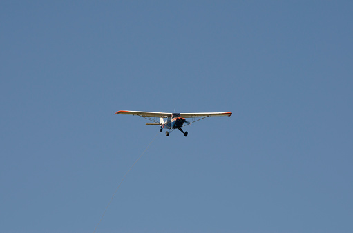 light plane flying head-on with blue sky in the background